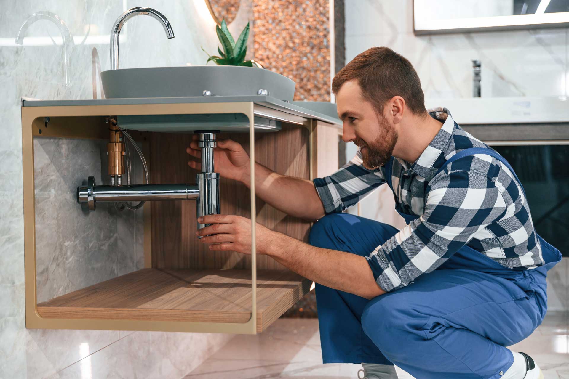 Plumber working under bathroom sink